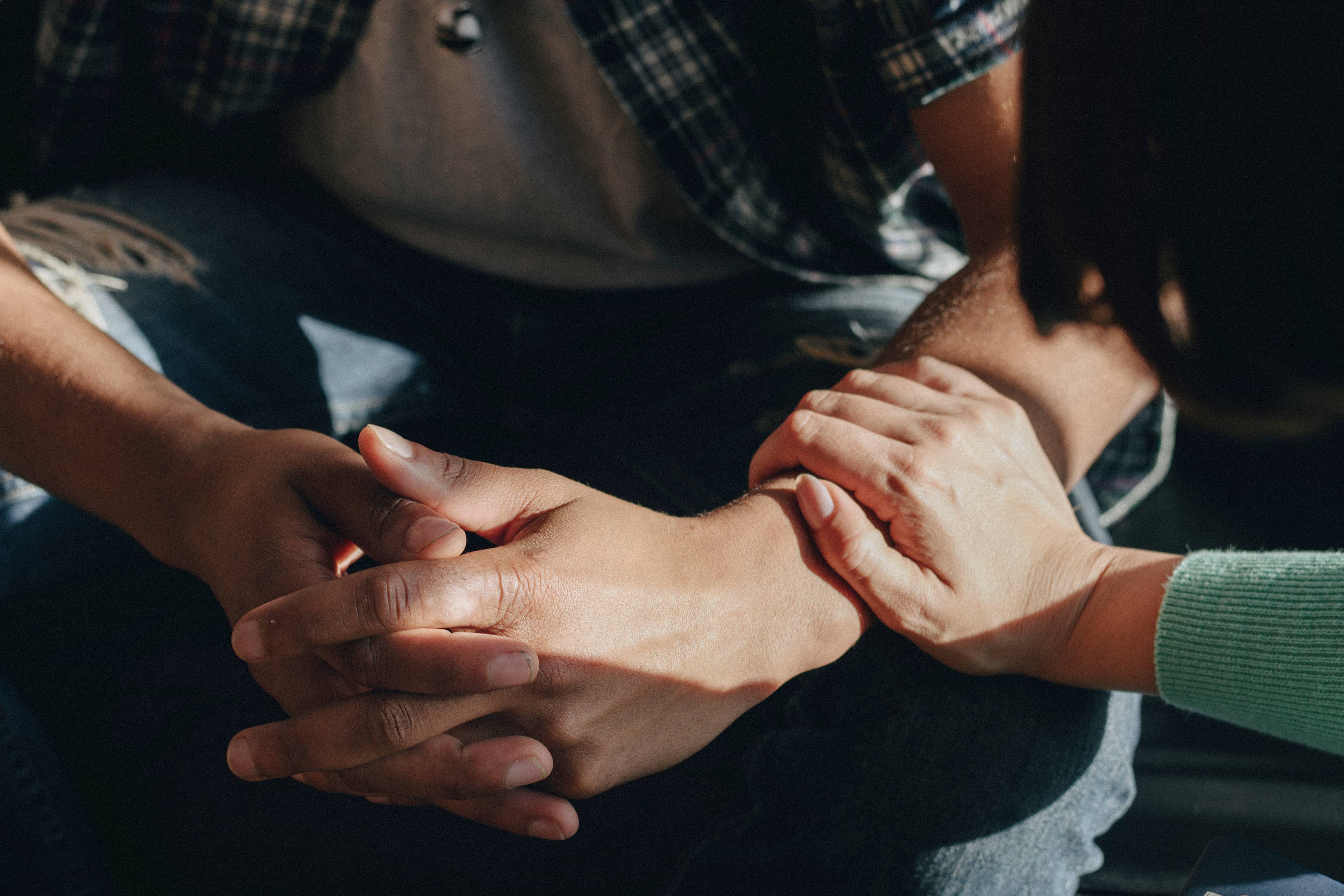 Person reaching out to hold the arm of another person