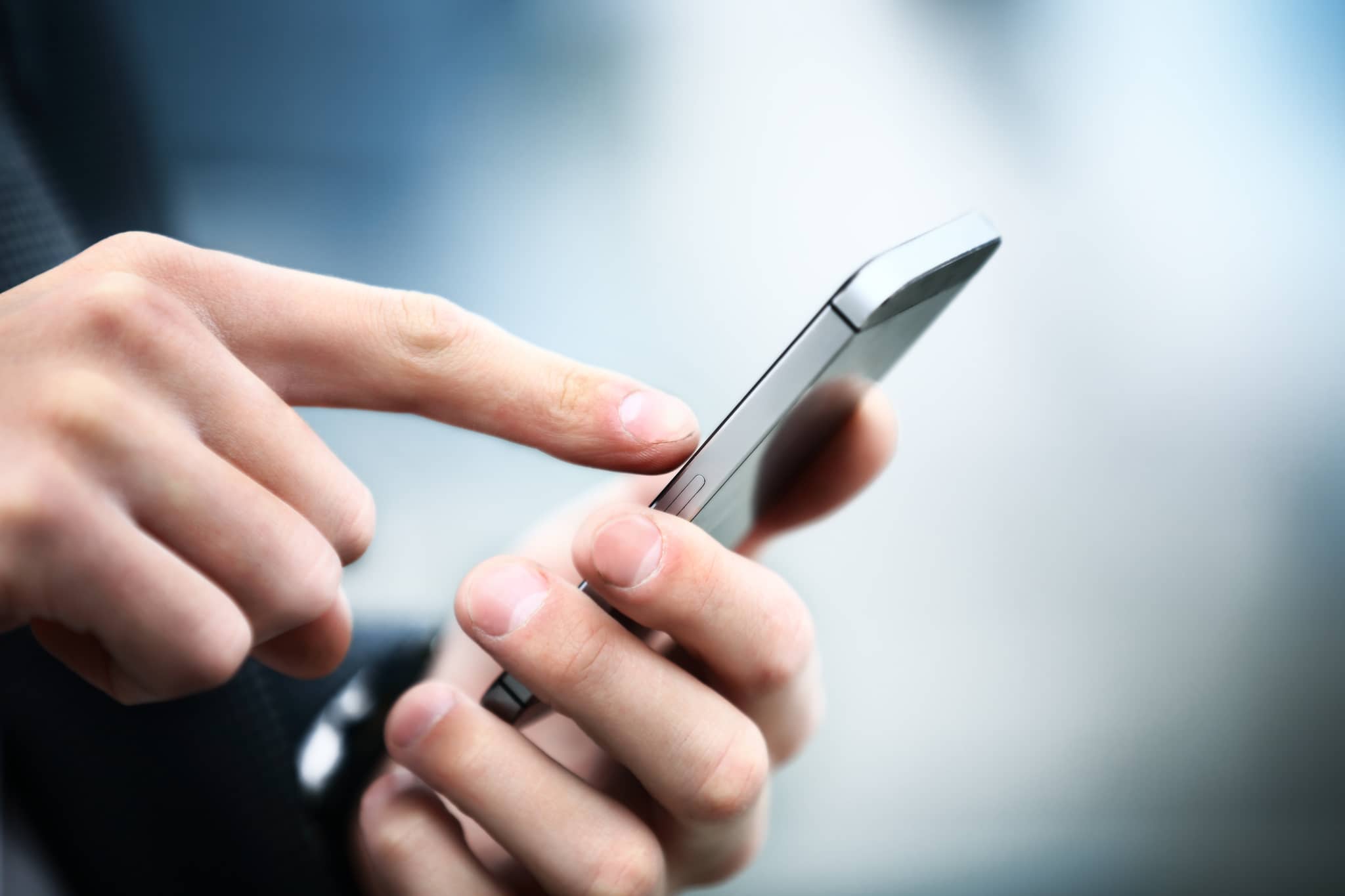 A Person placing a finger on a silver iphone