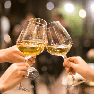 Two wine glasses clinking